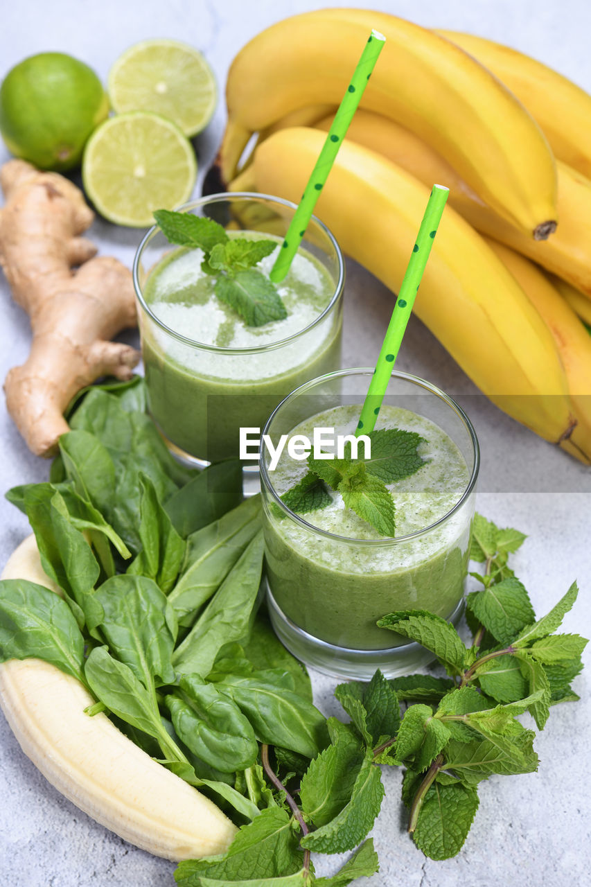 Fresh organic detox green drink smoothie with spinach, banana, lime and ginger with refreshing mint