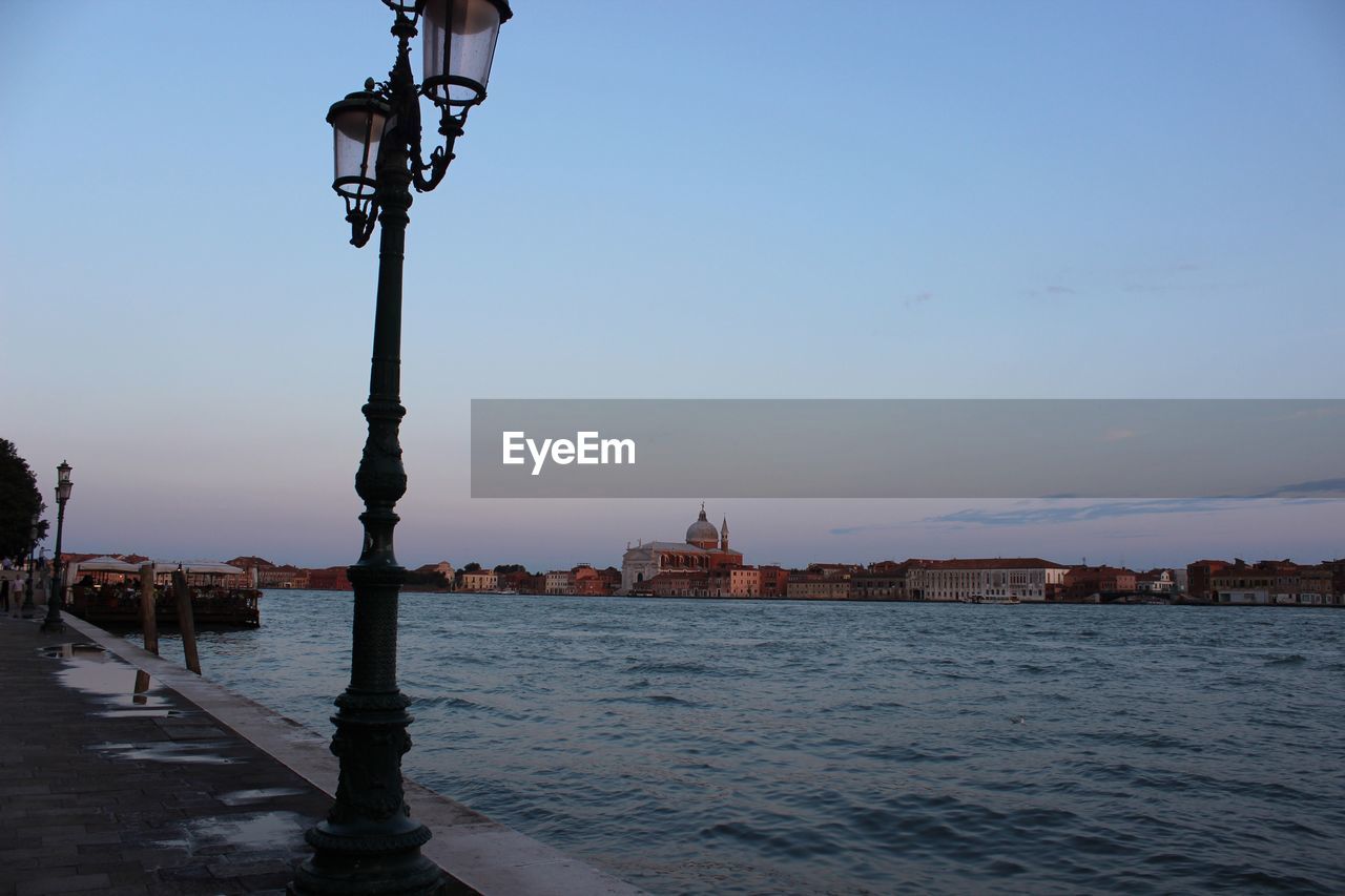 Lamp post on footpath by grand canal at dusk