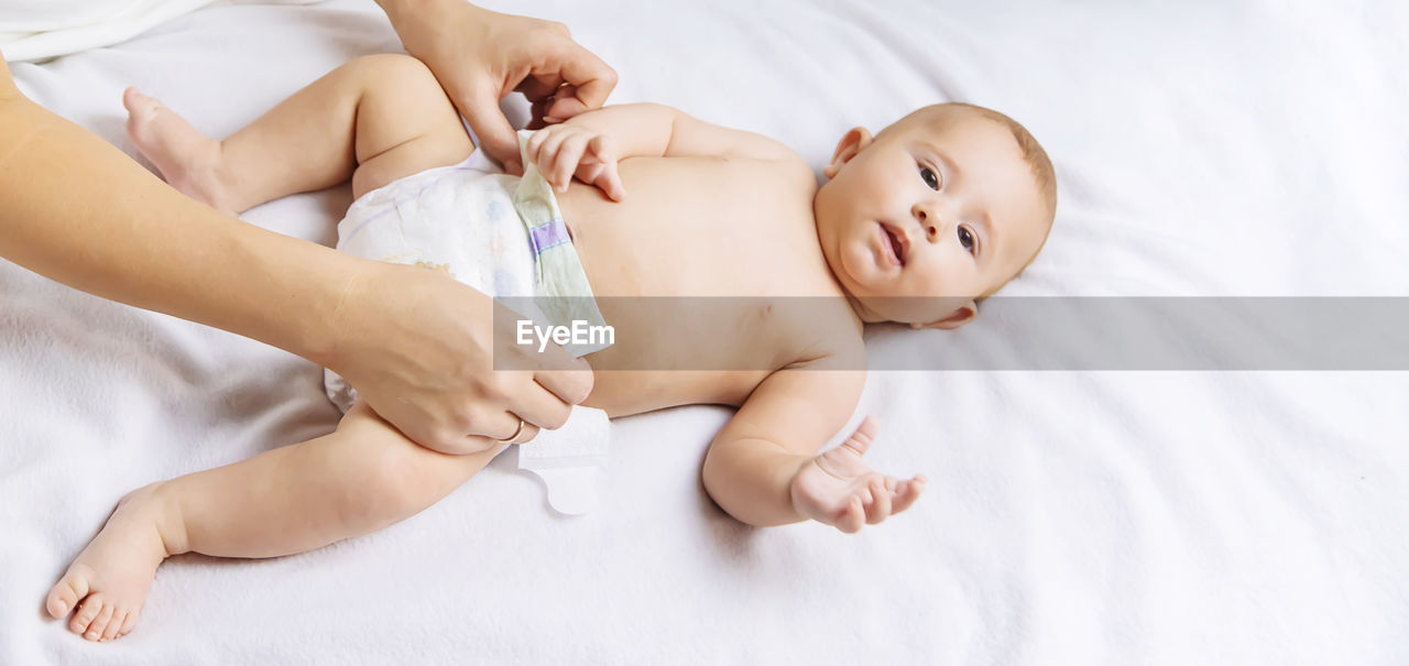 High angle view of baby girl lying on bed at home