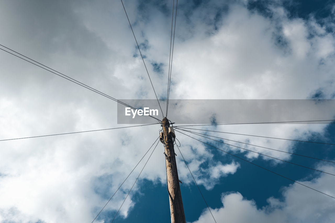 Low angle view of telephone line against cloudy sky