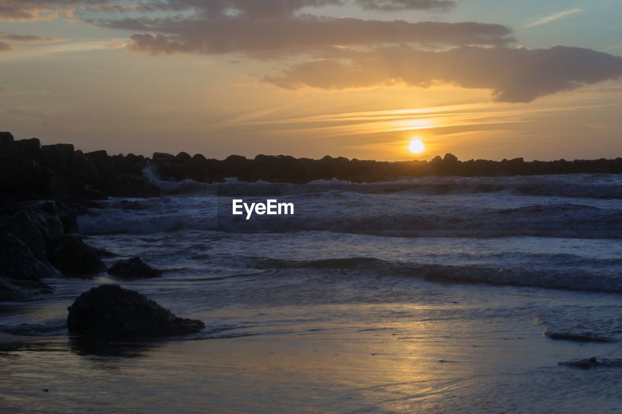 SCENIC VIEW OF BEACH DURING SUNSET