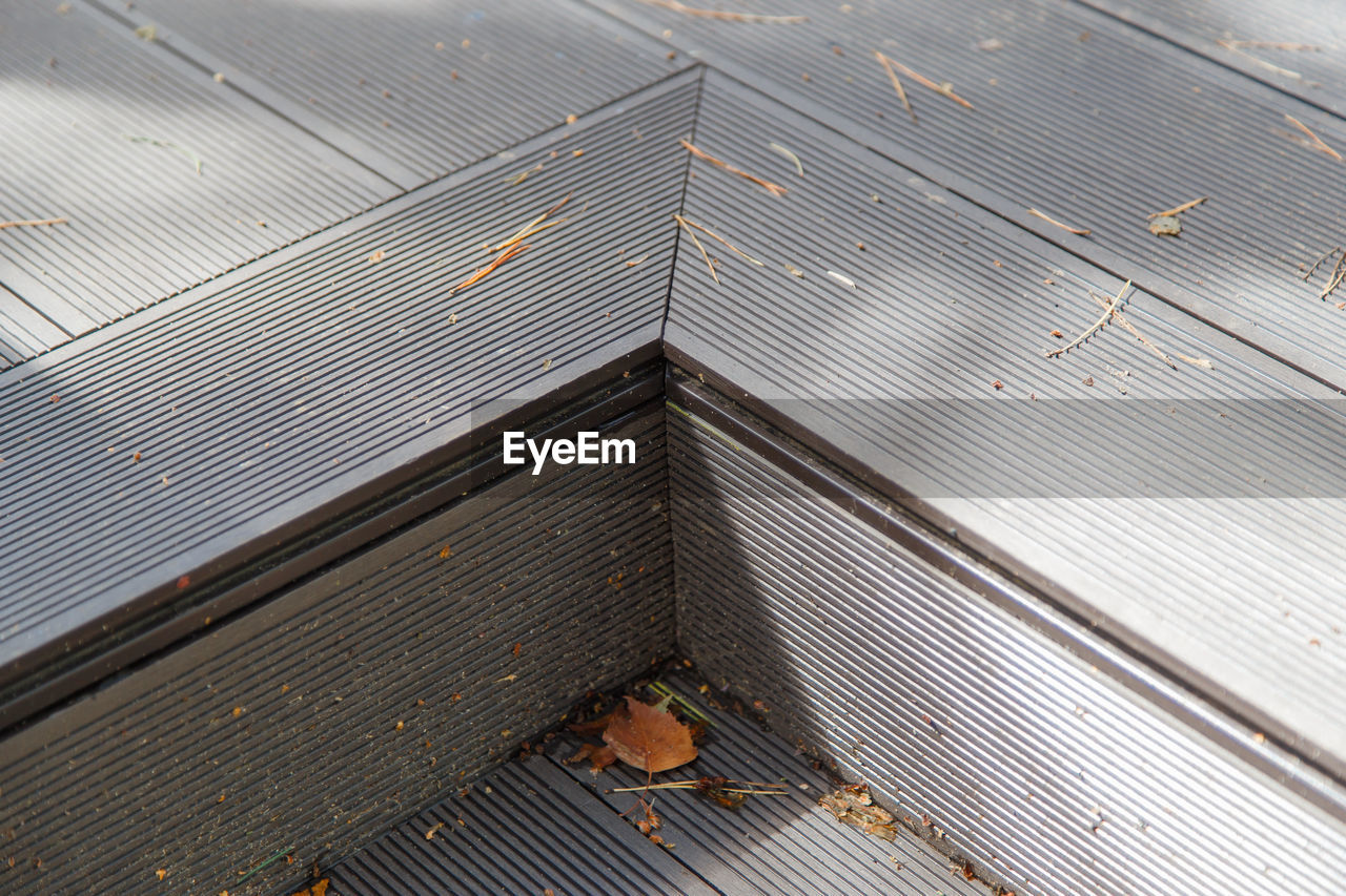 HIGH ANGLE VIEW OF ROOF AND LEAVES ON WOOD