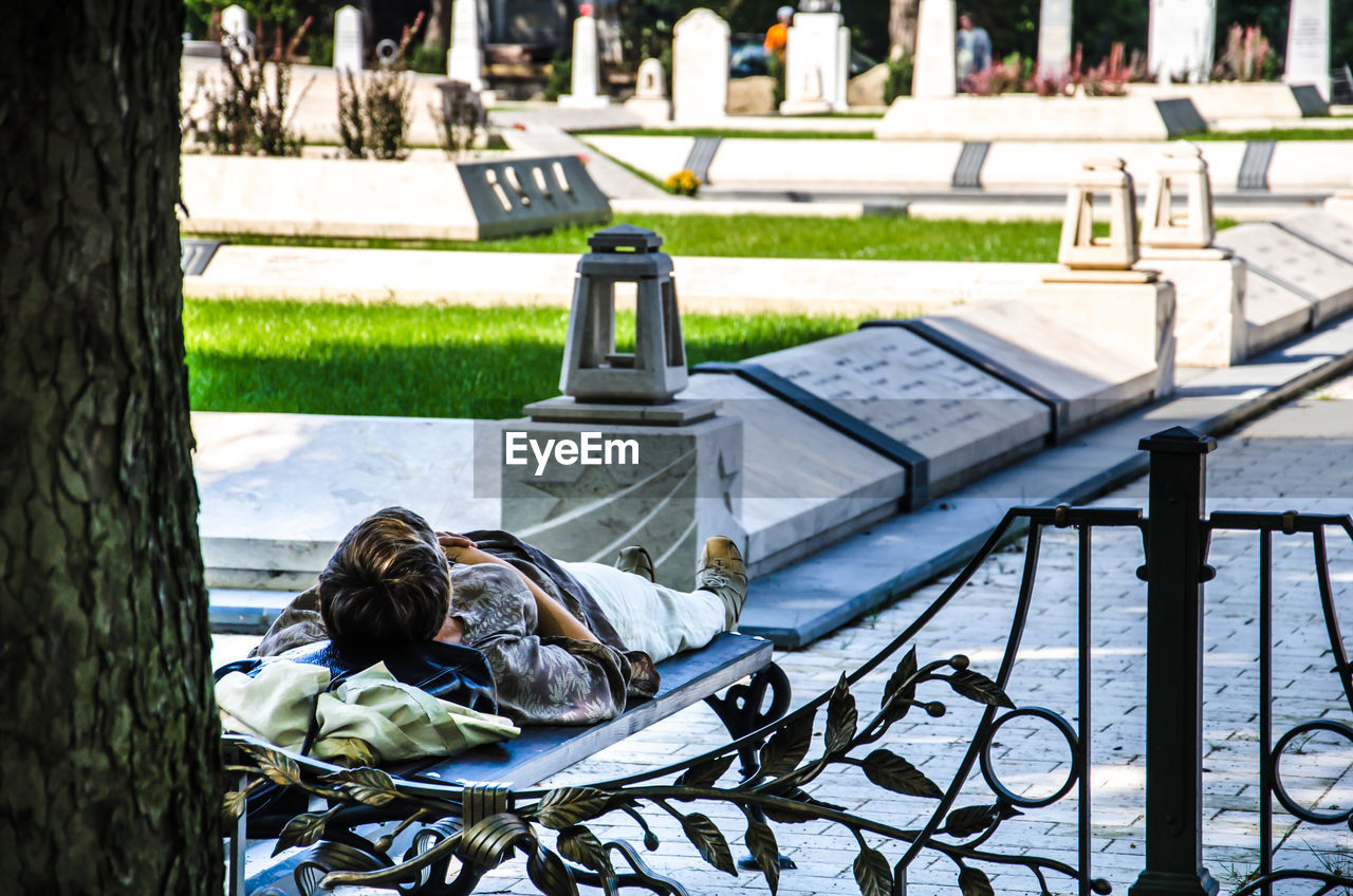 WOMAN SITTING ON PARK BENCH