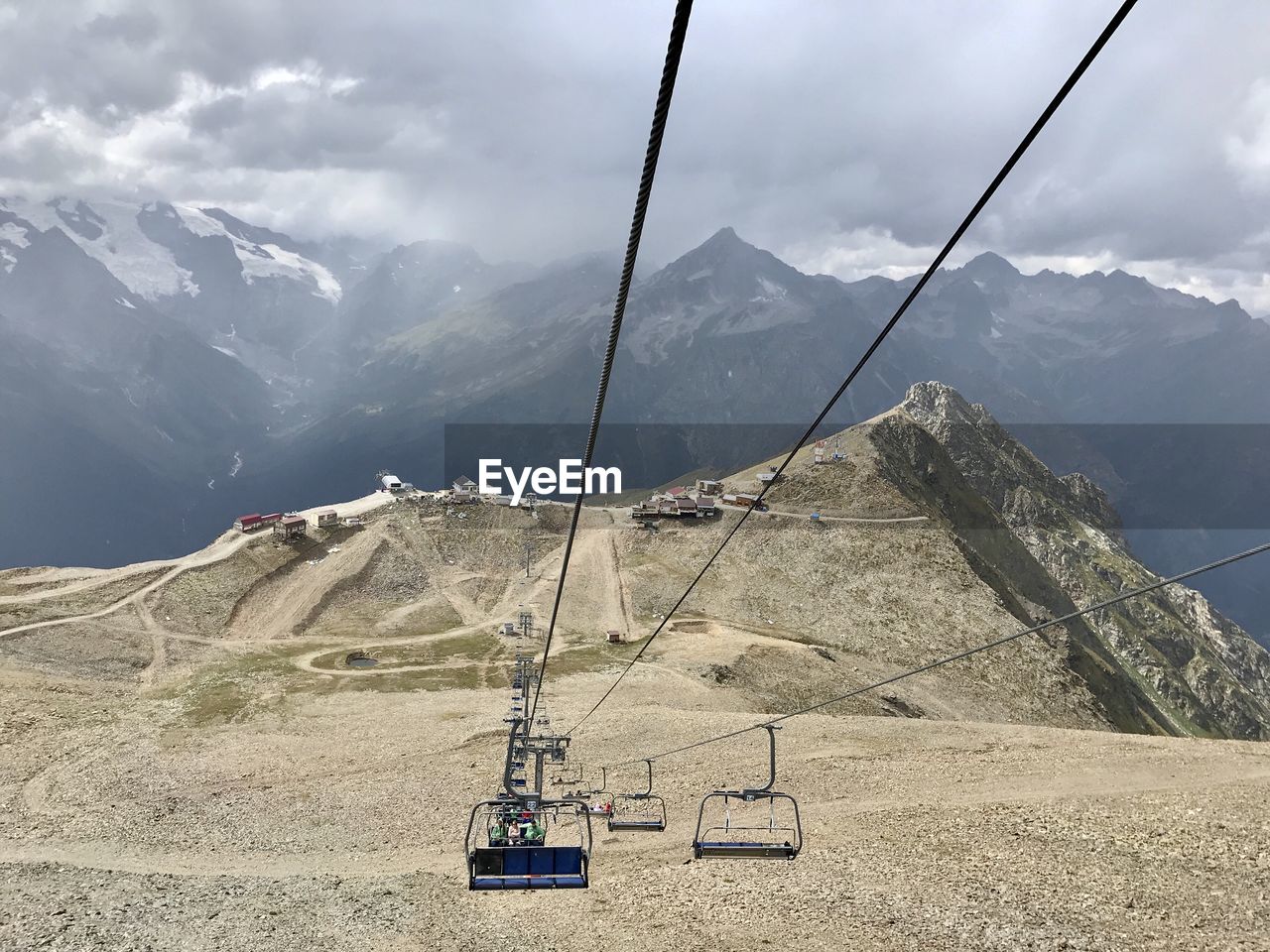 Overhead cable car over mountains against sky