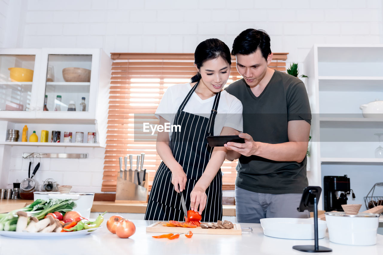 YOUNG WOMAN HOLDING FOOD AT HOME