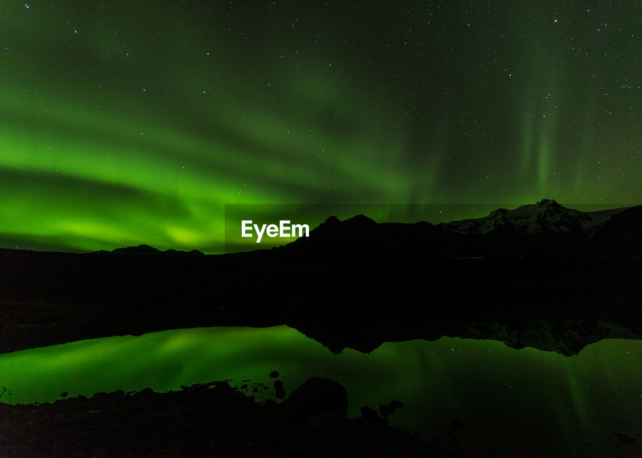 Scenic view of lake against sky at night