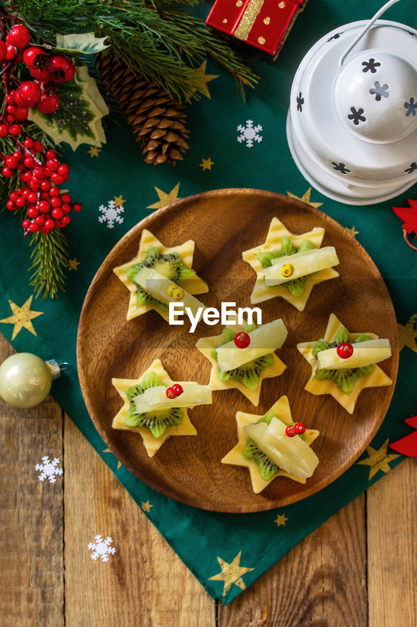 Festive snack of canapes on the christmas table. fruit canapes with cheese, kiwi and pineapple. 