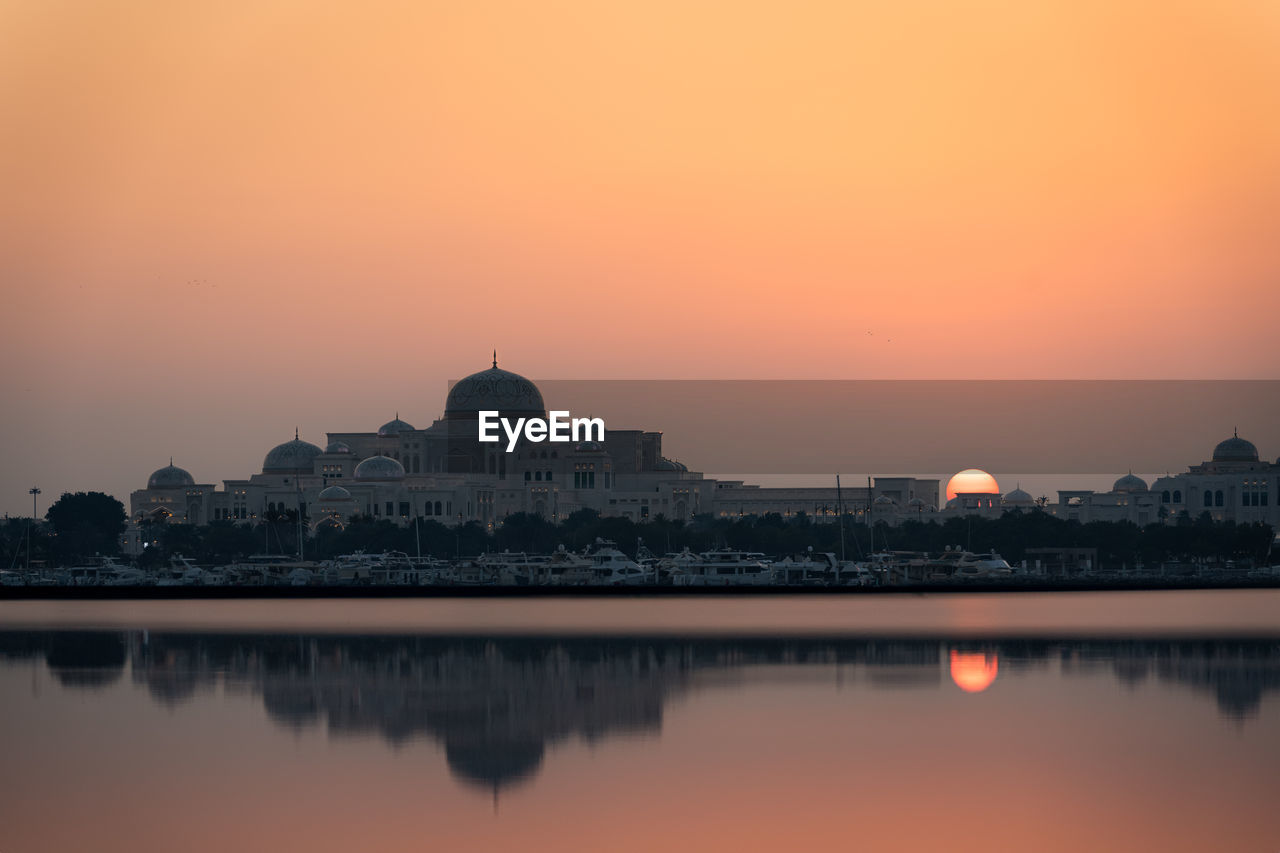 Abu dhabi skyline at the sunset with silhouette of the presidential palace qasr al watan
