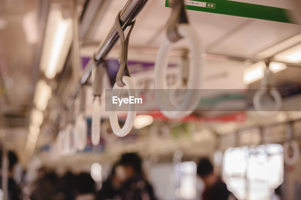 Close-up of handles hanging in train