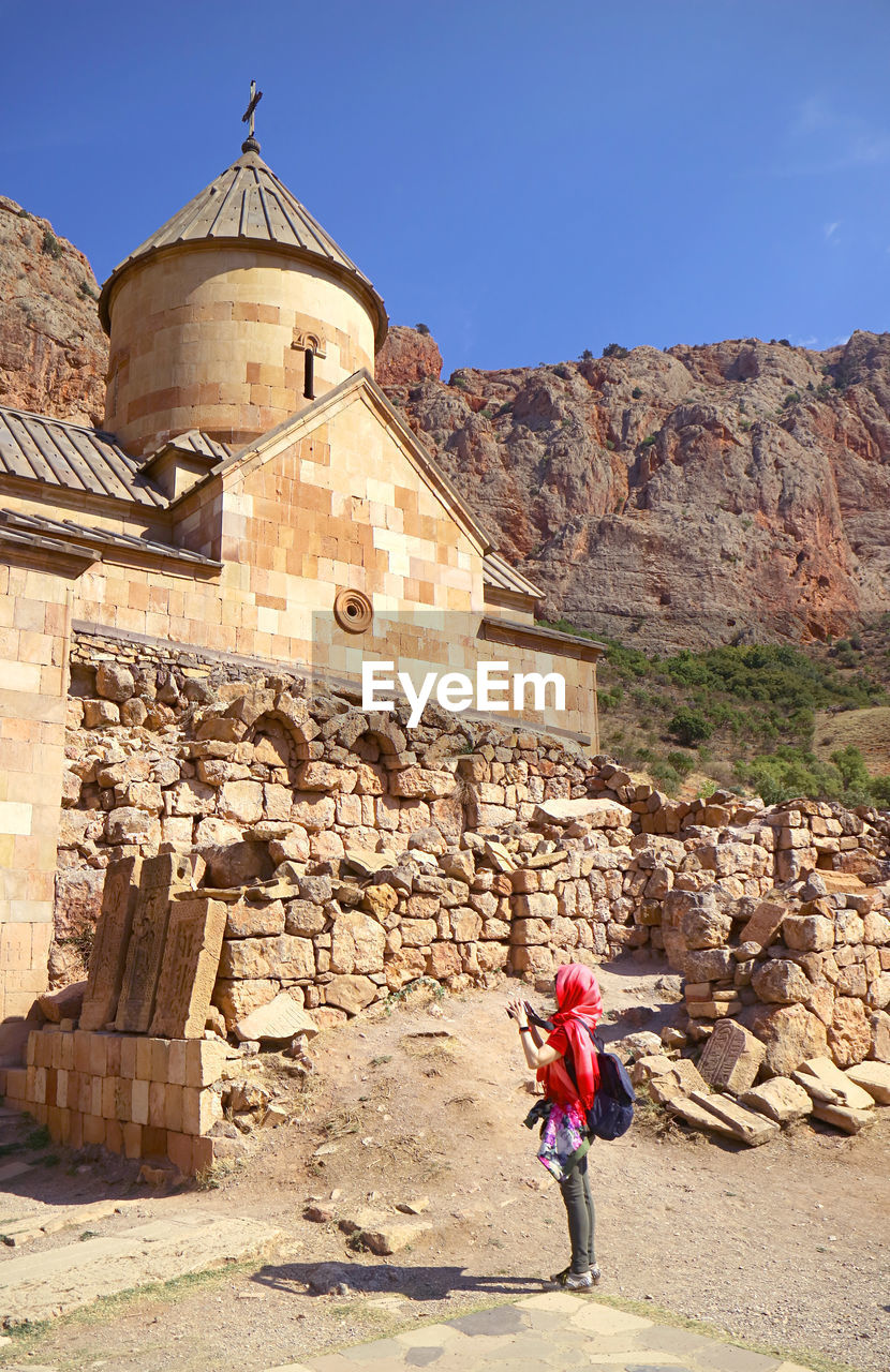 Female taking photos of the surb karapet in noravank monastery, armenia