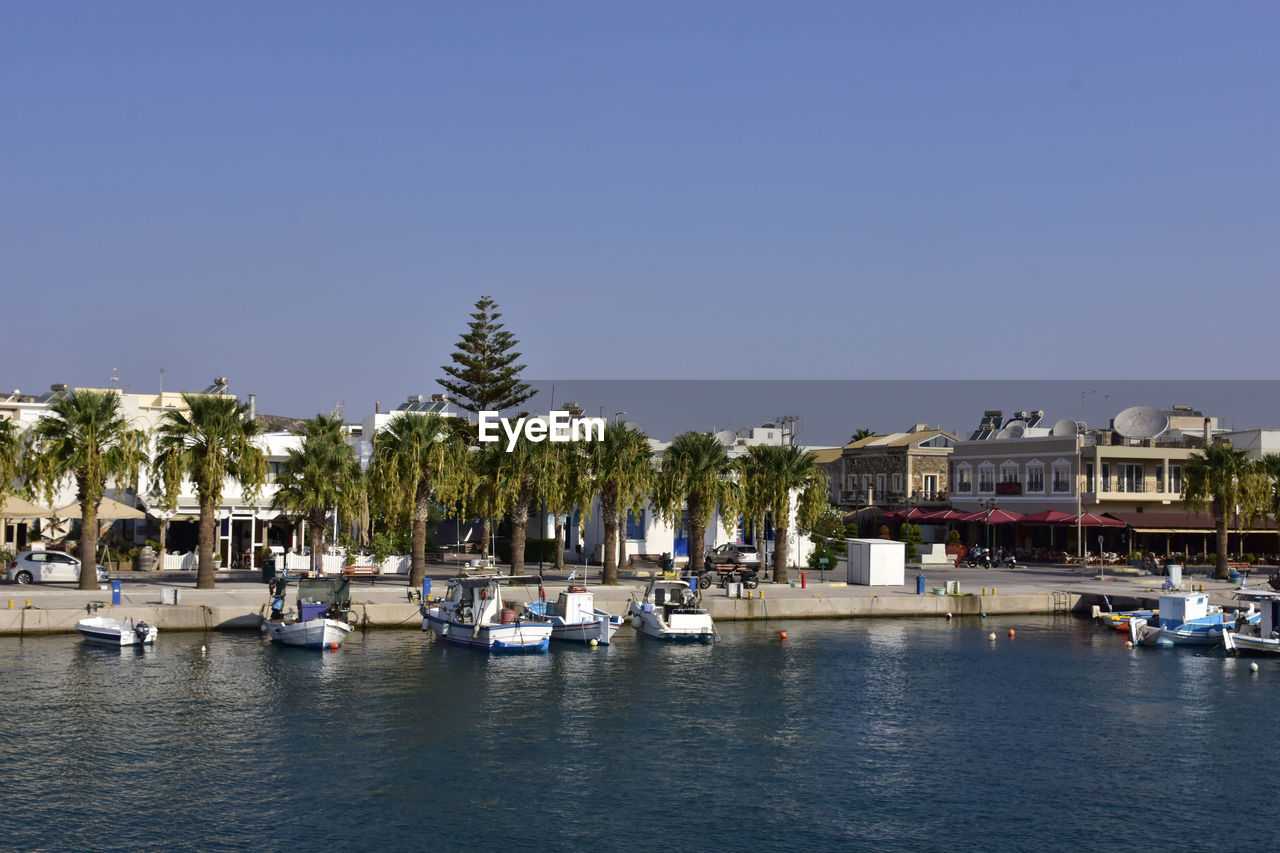 water, marina, nautical vessel, dock, transportation, architecture, sky, mode of transportation, nature, building exterior, clear sky, built structure, harbor, travel destinations, sea, ship, tree, building, travel, palm tree, vehicle, city, waterfront, bay, vacation, moored, tropical climate, day, plant, tourism, boat, land, blue, no people, beach, outdoors, yacht, sunny, sailboat, holiday, trip, pier, house, landscape, watercraft, luxury, residential district