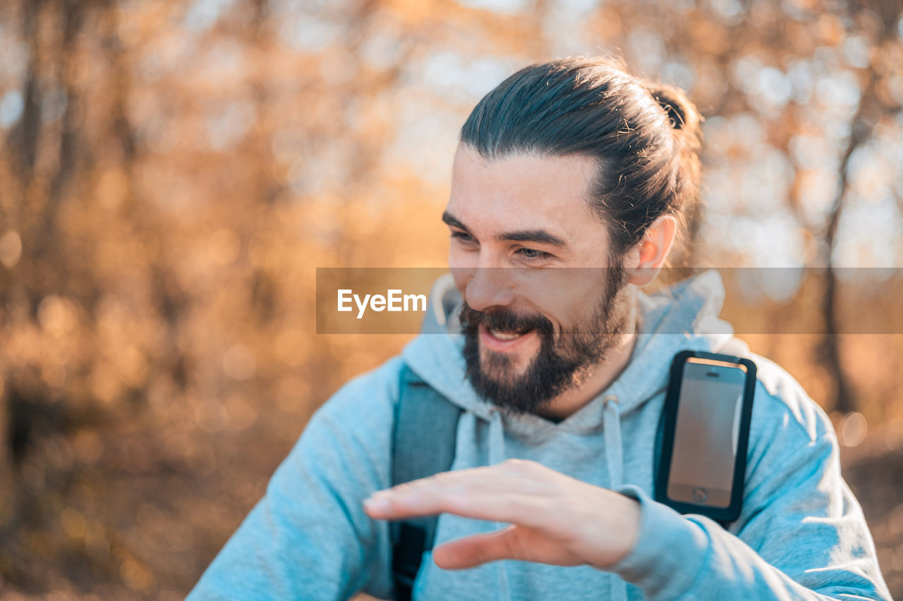 PORTRAIT OF MAN USING SMART PHONE