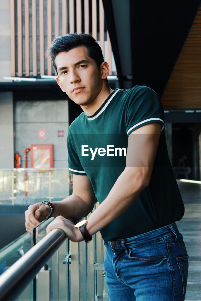 Portrait of young man standing in corridor