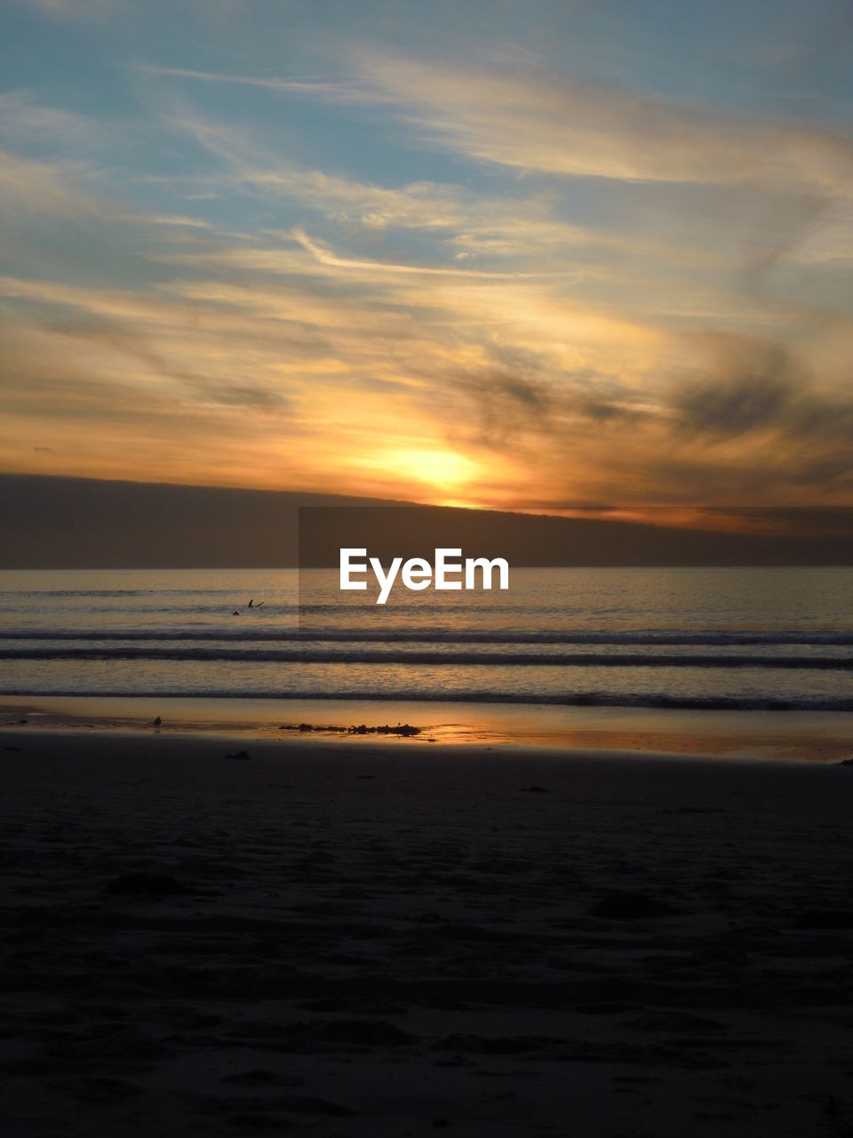 Scenic view of beach and sea against sunset sky