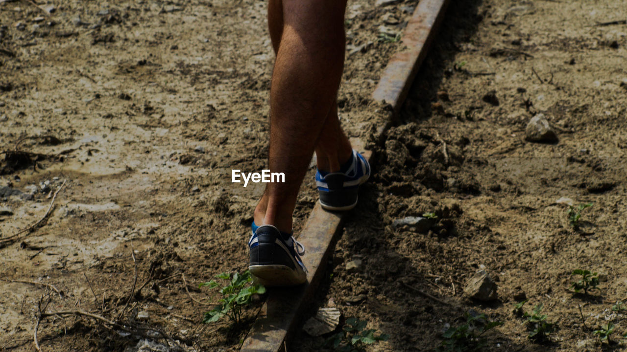 LOW SECTION OF MAN STANDING ON MUD