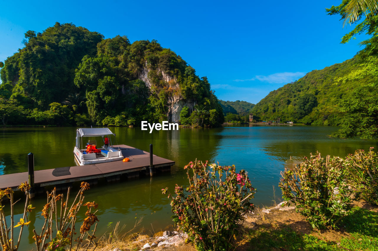 Scenic view of lake and mountains against blue sky