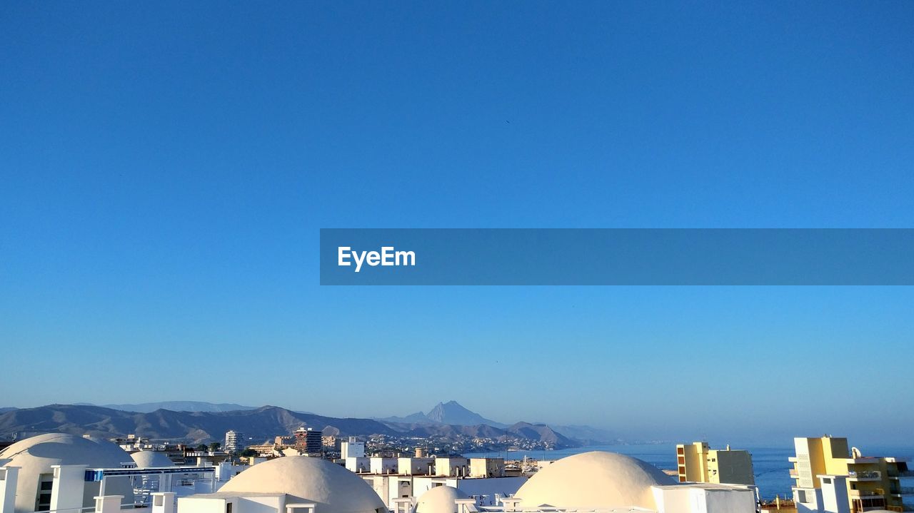 Cityscape against clear blue sky