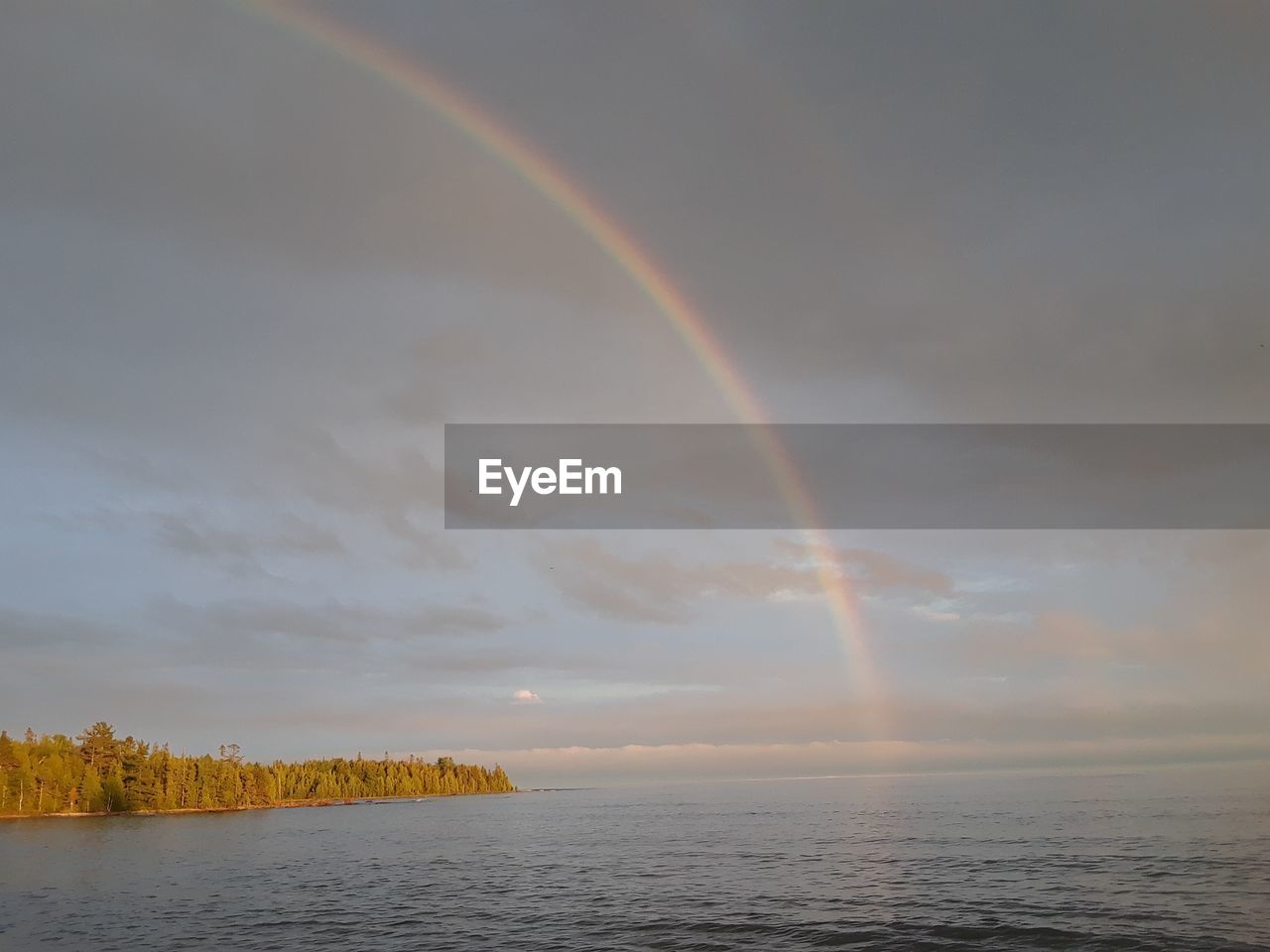 RAINBOW OVER SEA AGAINST SKY