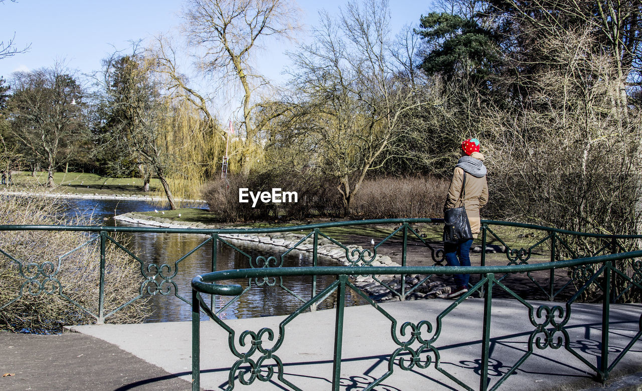 Rear view of woman standing on footbridge