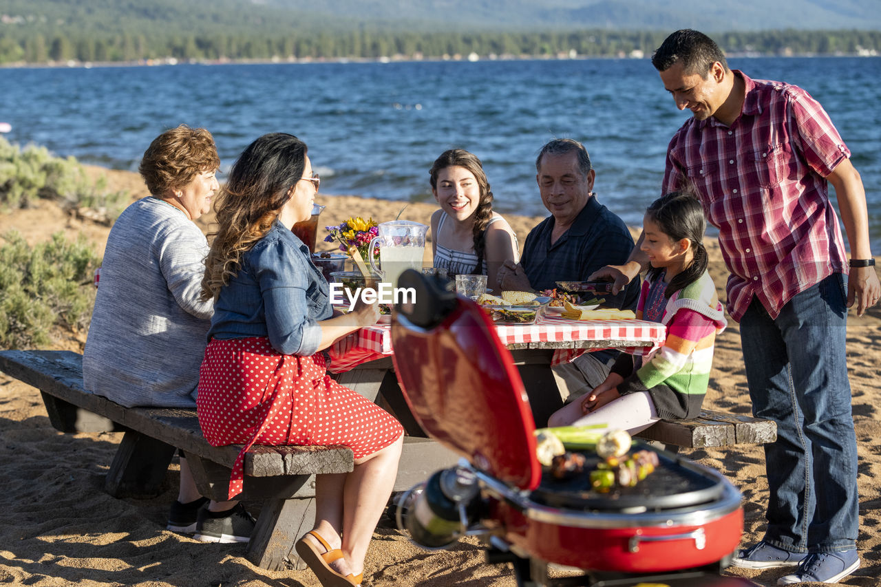 A family enjoys a beach bbq on the shoreline of lake tahoe, nv