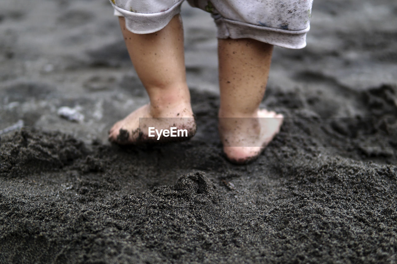 Low section of child standing on beach