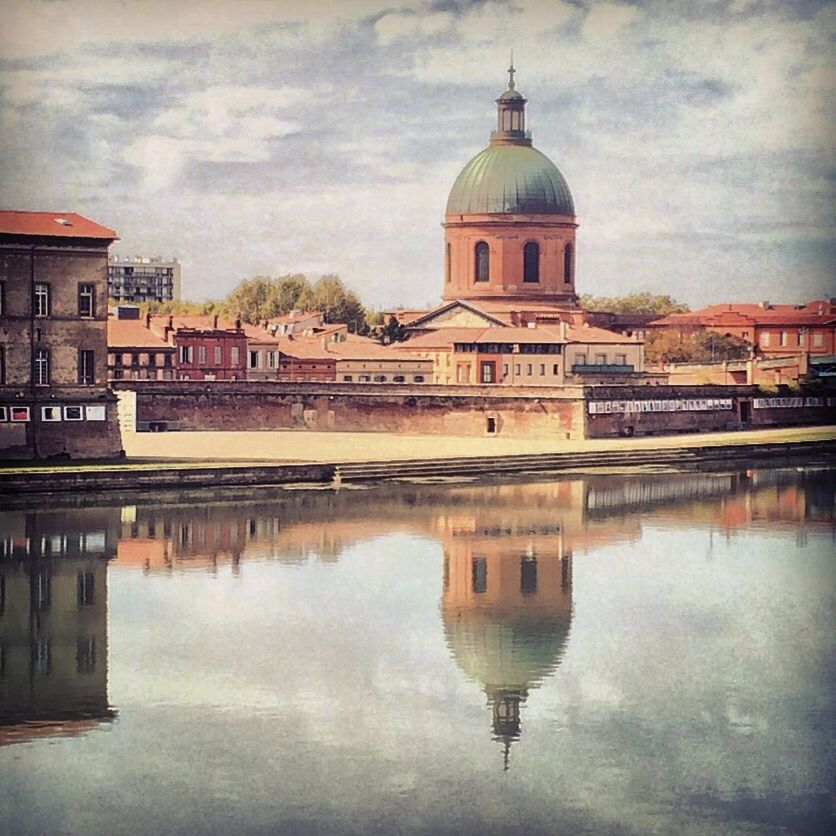 Church against cloudy sky in city