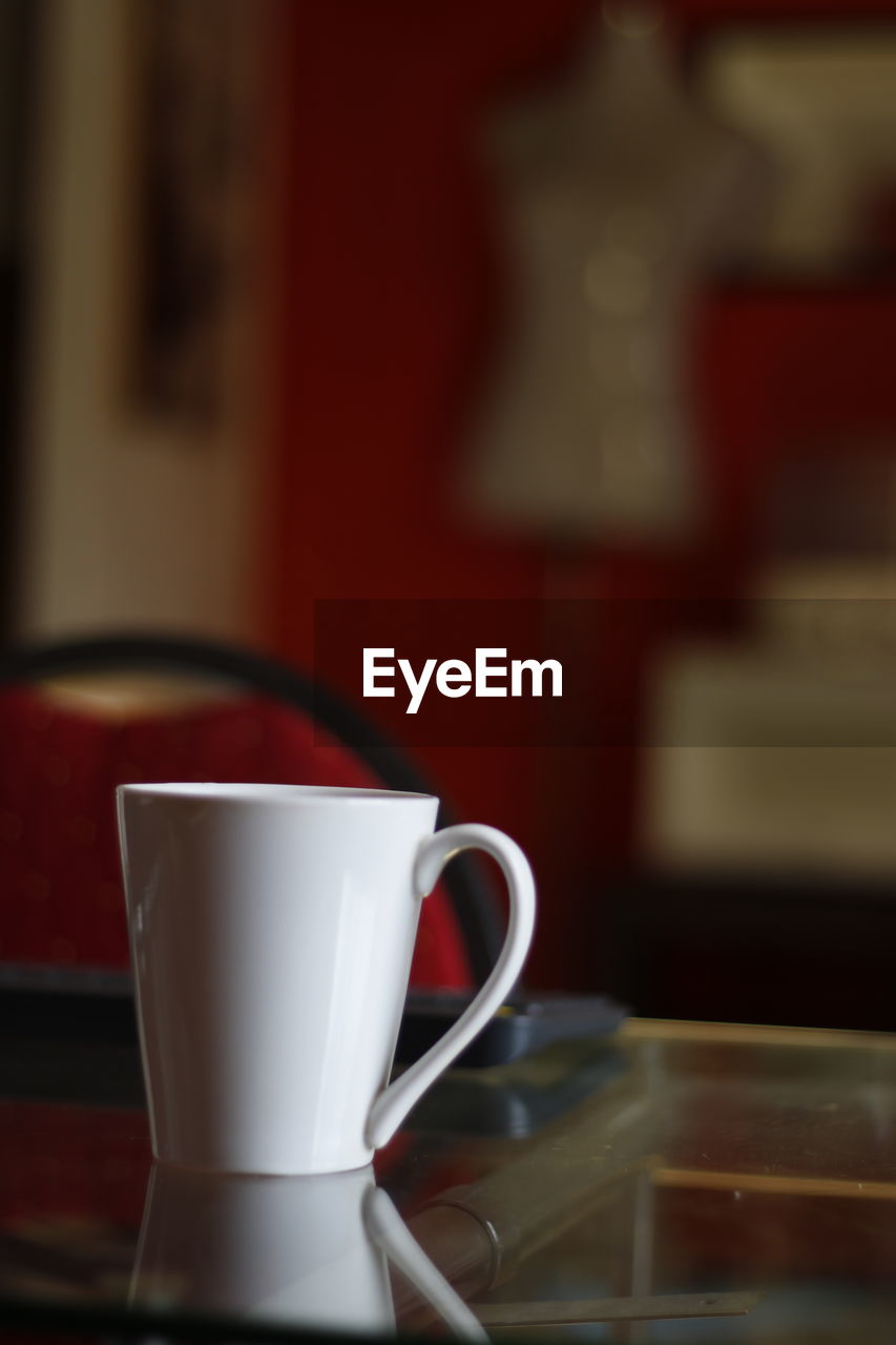 CLOSE-UP OF COFFEE CUP ON TABLE AT HOME