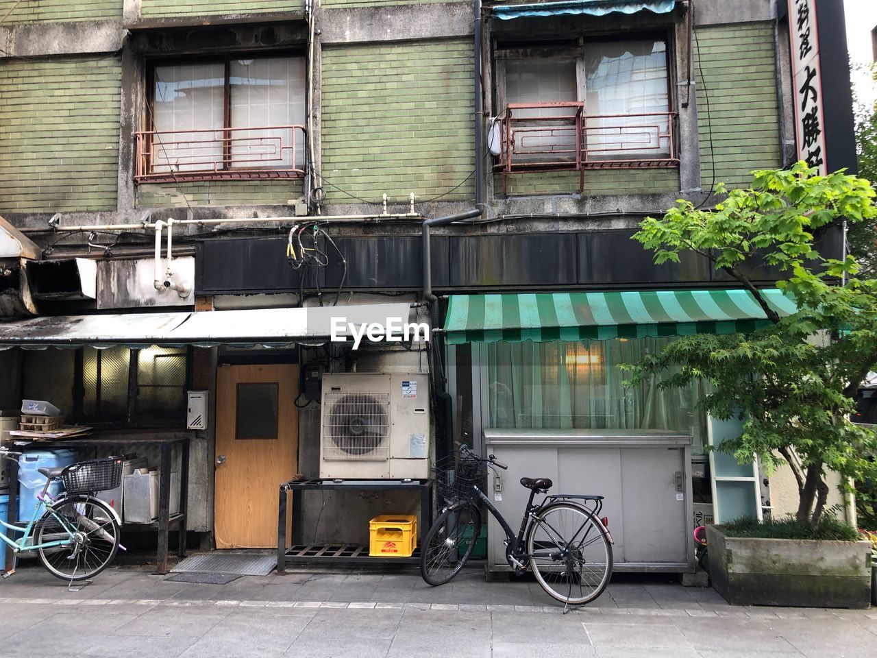 BICYCLES PARKED ON STREET BY BUILDING