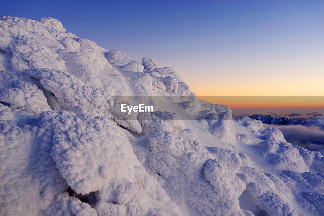 SNOW COVERED LANDSCAPE AGAINST SKY