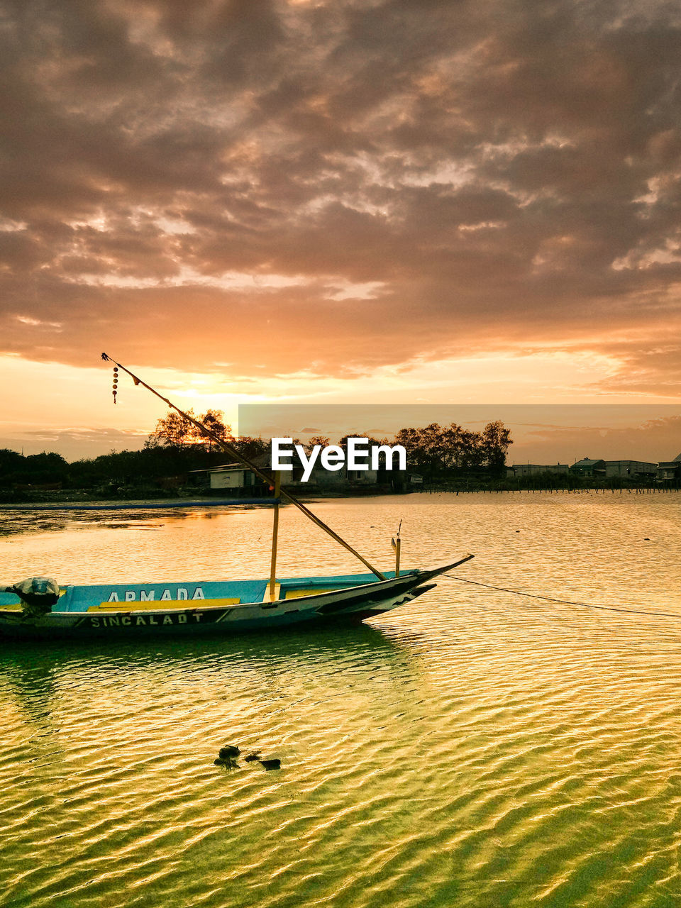 BOAT SAILING ON RIVER AGAINST SKY DURING SUNSET