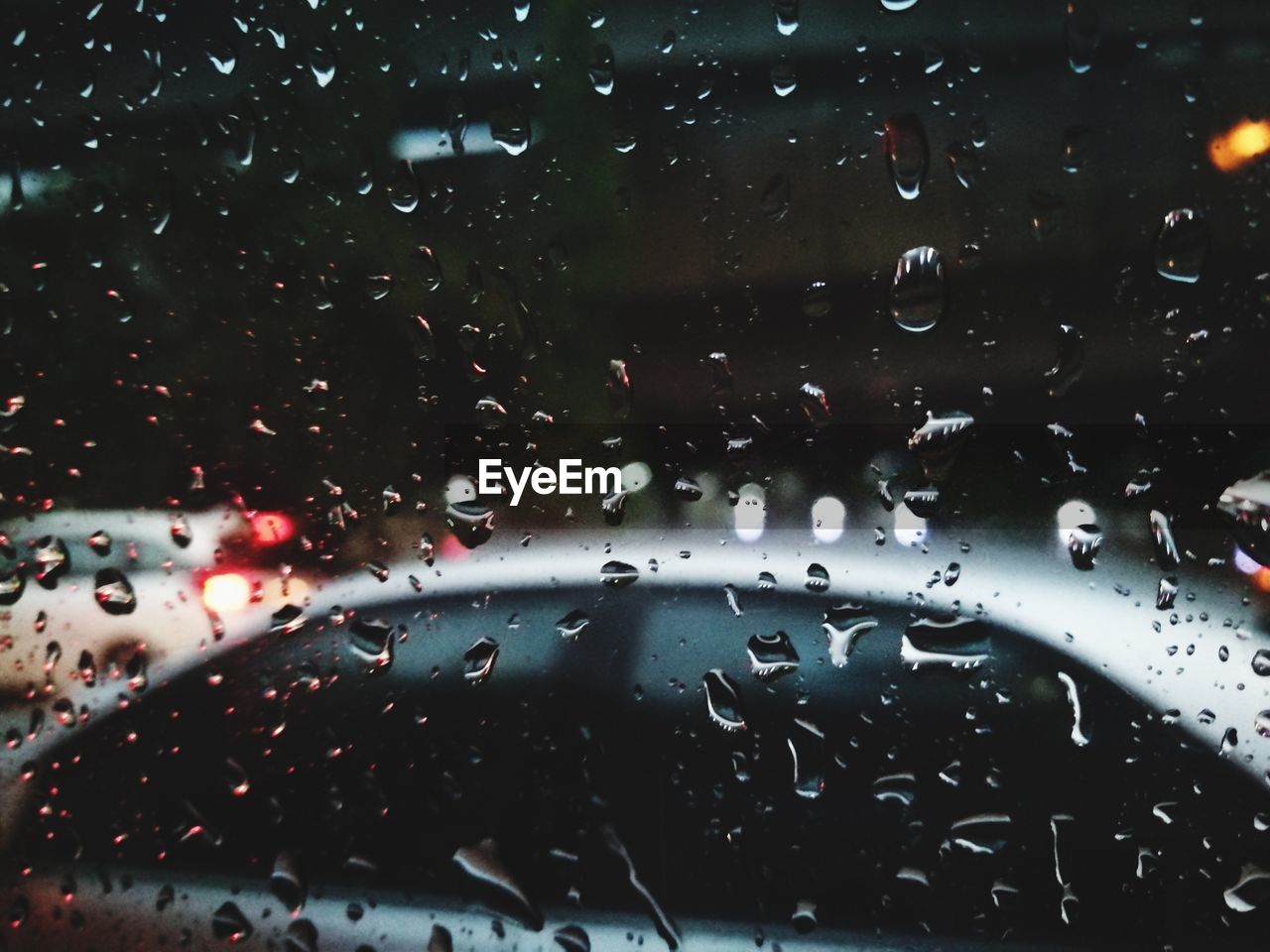 CLOSE-UP OF WATERDROPS ON WINDSHIELD OF CAR