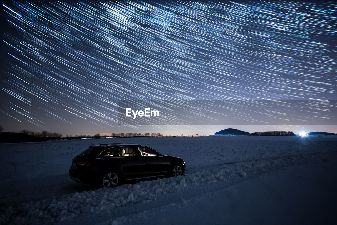 Car on illuminated mountain against sky at night