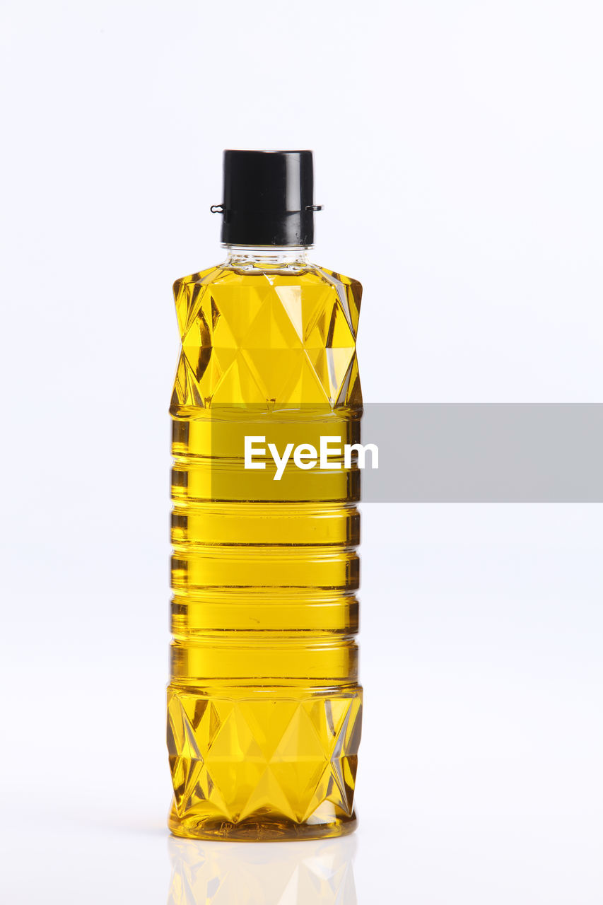 Close-up of cooking oil in bottle against white background