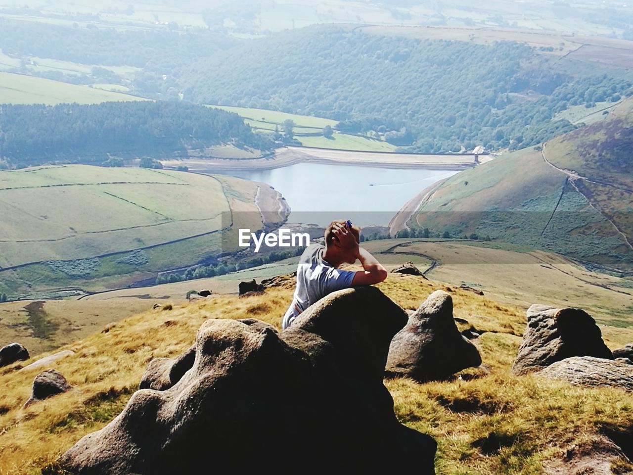 Man looking away while standing by rock