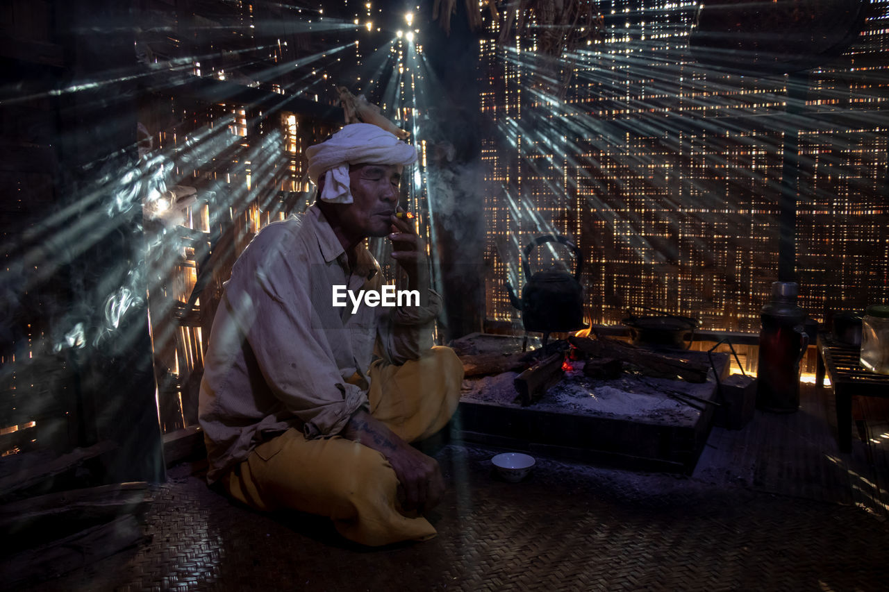 MAN WORKING AT NIGHT IN ILLUMINATED STREET