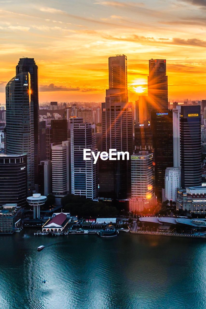 Modern buildings against sky during sunset in city