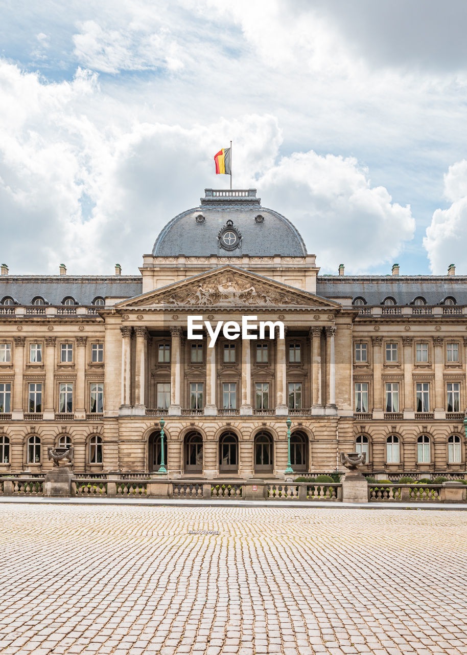 Facade of historical building against cloudy sky