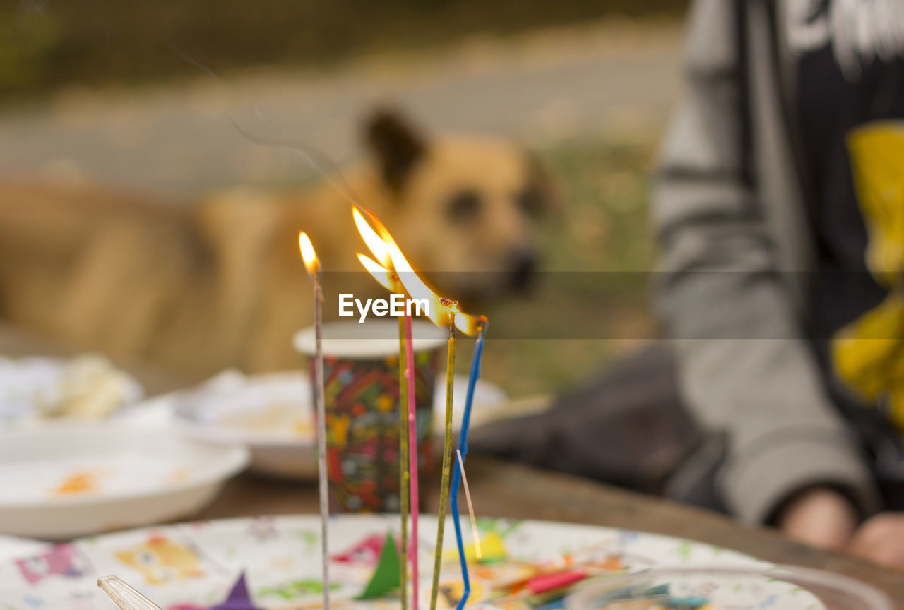 Close-up of lit candles on table