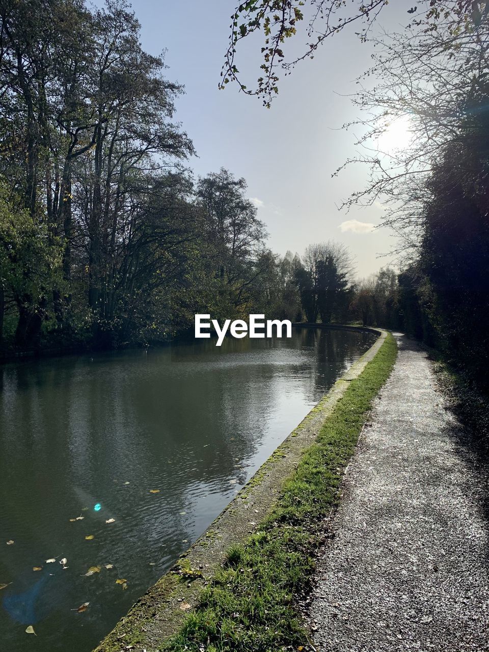 VIEW OF FOOTPATH BY CANAL AGAINST SKY