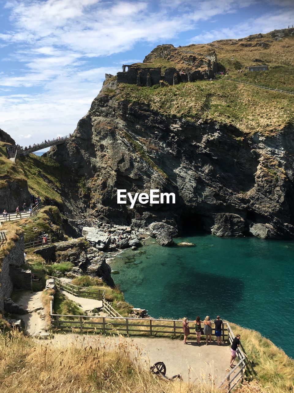 Scenic view of sea by cliff against sky