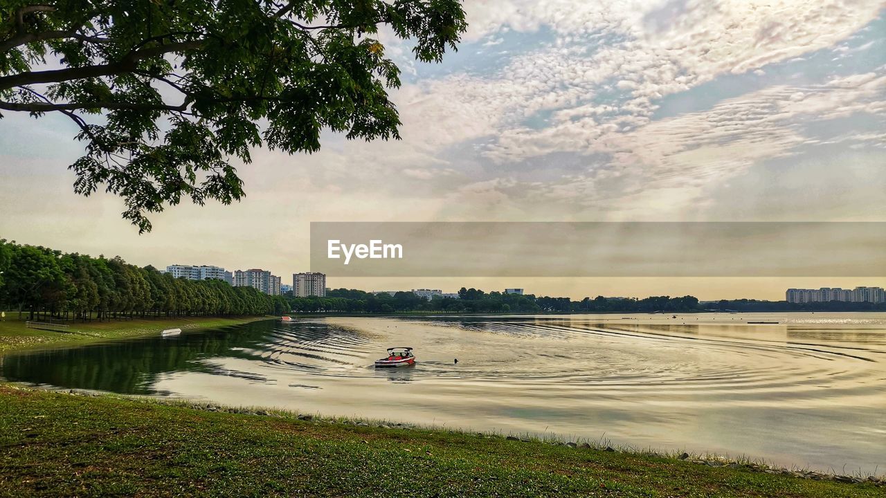 Scenic view of reservoir with speedboat gliding on it