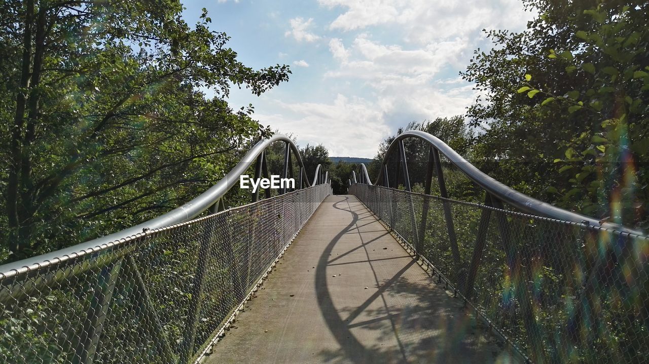 FOOTBRIDGE AGAINST TREES AND SKY