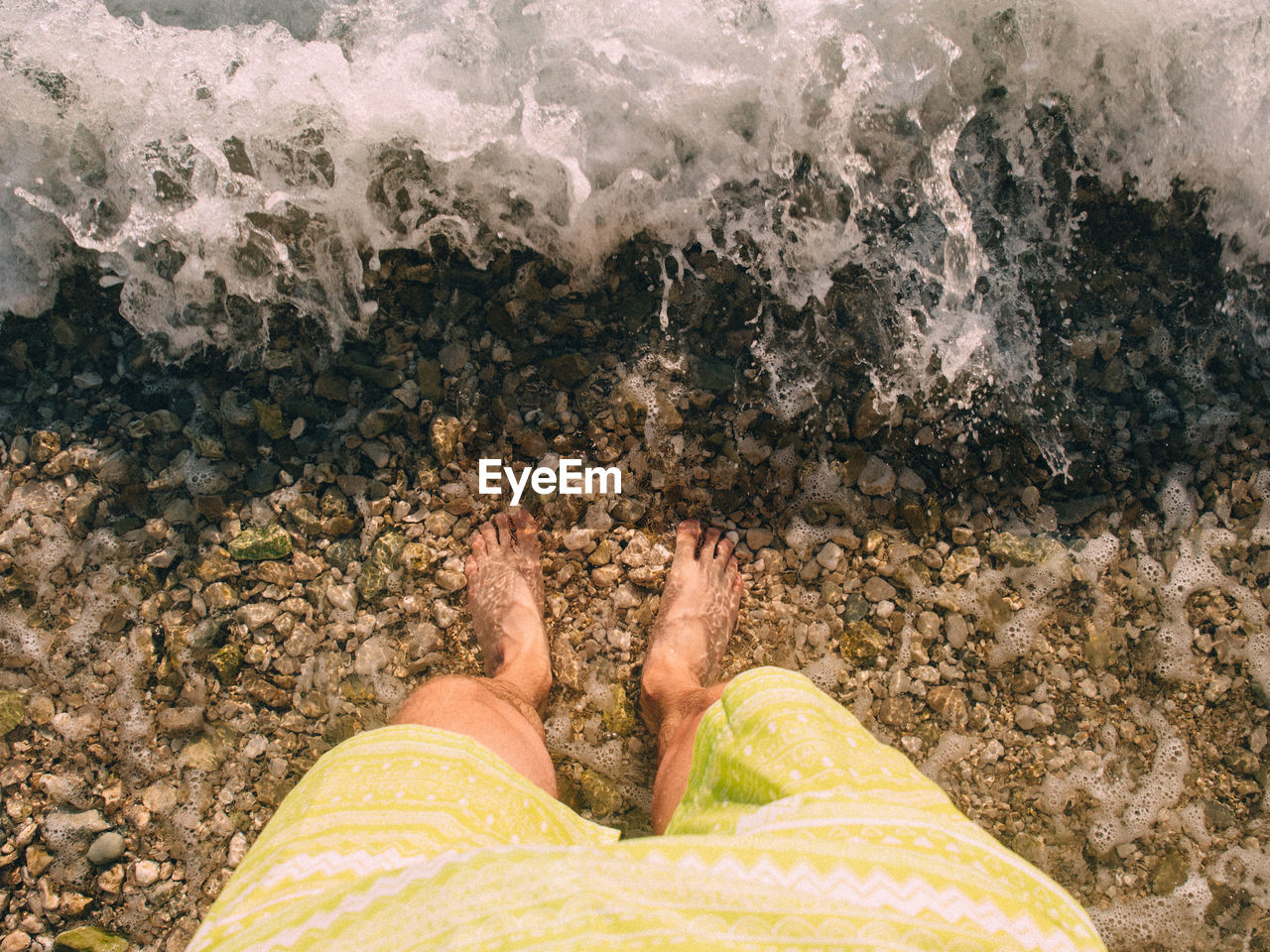 Low section of person standing on beach