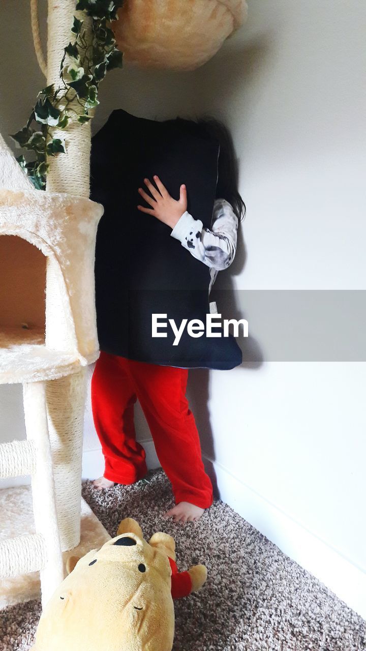 LOW SECTION OF CHILD STANDING ON HARDWOOD FLOOR