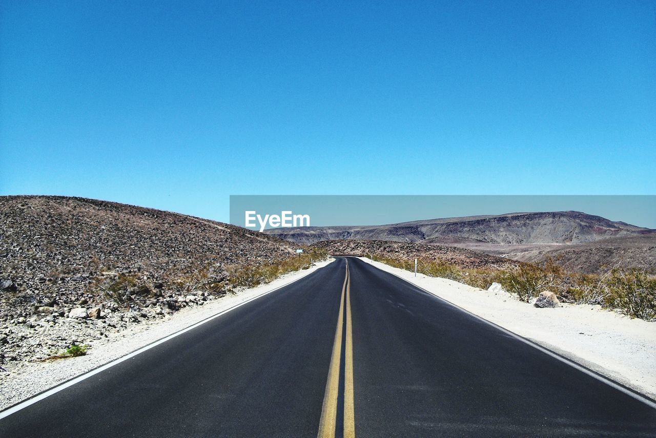 EMPTY ROAD ALONG LANDSCAPE AGAINST CLEAR BLUE SKY