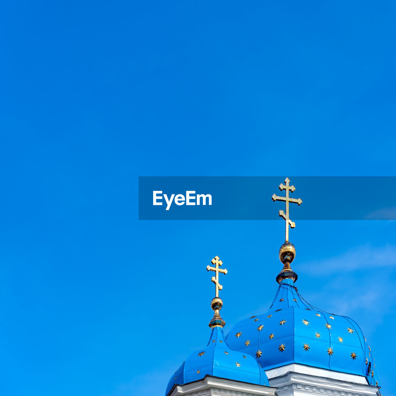 Christian orthodox church cupolas with blue roofs, golden stars and golden crosses 