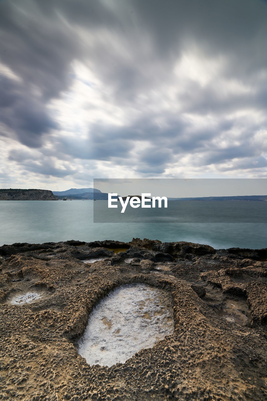 ROCKS ON BEACH AGAINST SKY