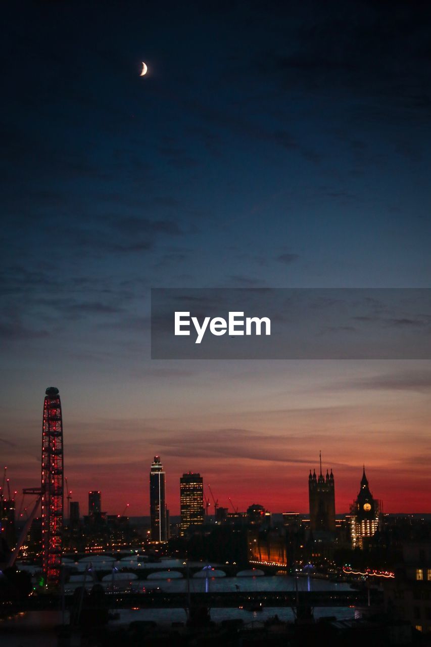 Aerial view of illuminated cityscape against sky at dusk