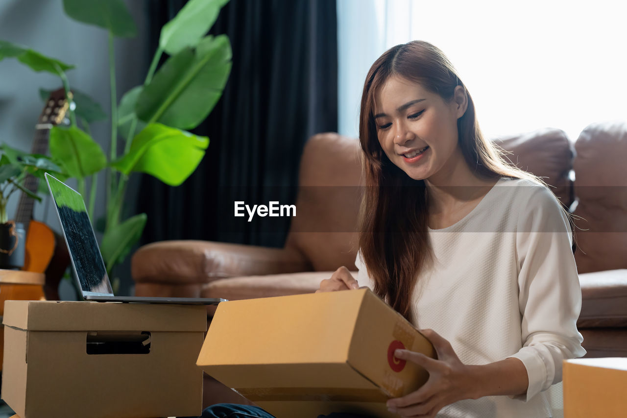 portrait of young woman using digital tablet while sitting on table