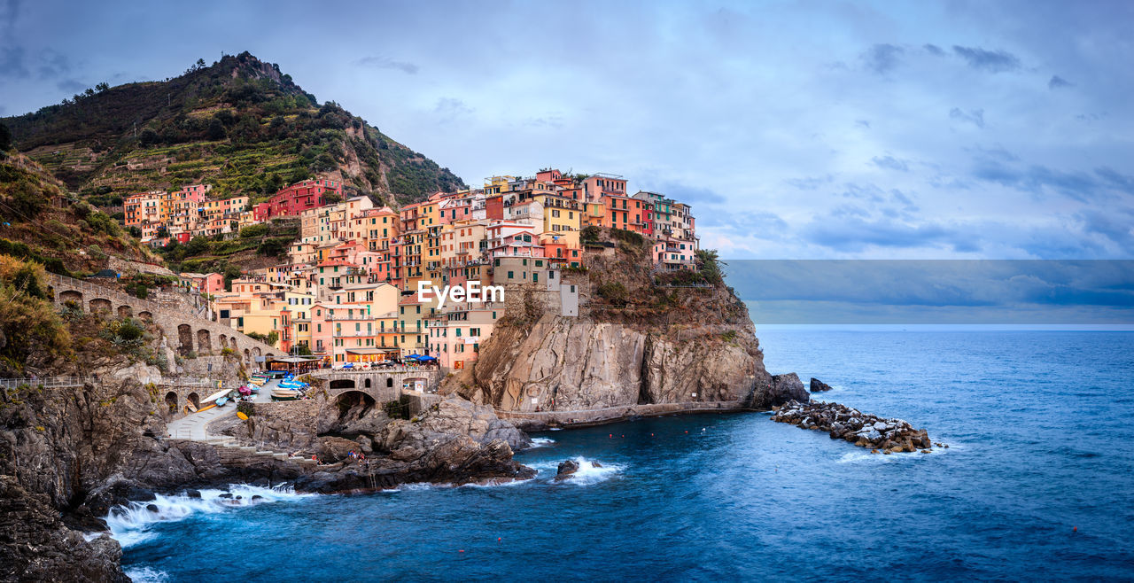 PANORAMIC VIEW OF SEA BY BUILDINGS AGAINST SKY